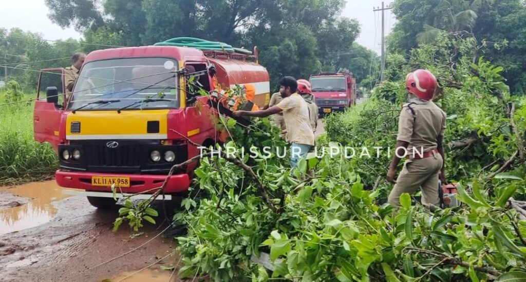 തൃശ്ശൂർ പുഴക്കൽ പാടത്തിനു സമീപം ഓടികൊണ്ടിരിക്കുന്ന വേസ്റ്റ് വാട്ടർ വണ്ടിക്കു മുകളിലേക്കു മരവും പോസ്റ്റും ഒടിഞ്ഞു വീണു; യാത്രികർ രക്ഷപെട്ടു